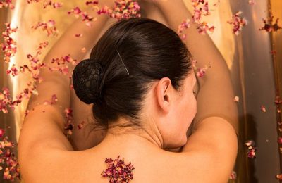 Frau genießt Massage mit Blüten